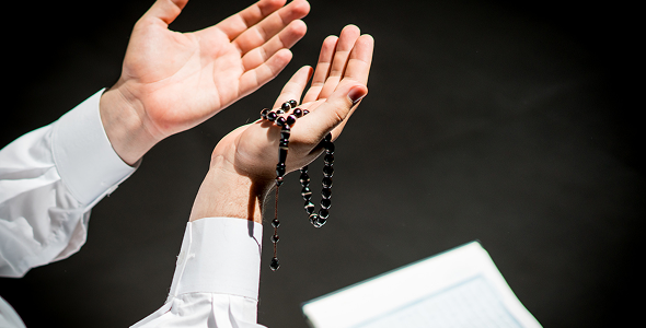 Hands in prayer with prayer beads