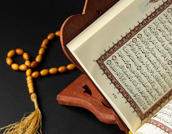 Quran with prayer beads and Islamic calligraphy